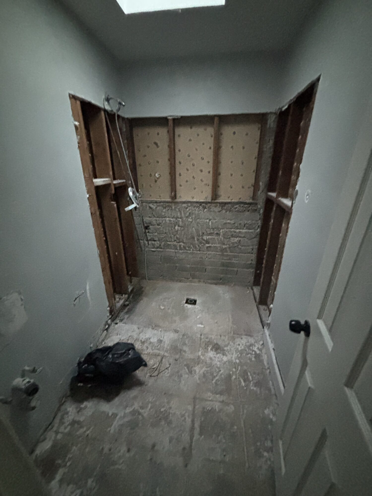 Bathroom stripped to the studs during an interior demolition by OSR — shower and wall tile removed for renovation